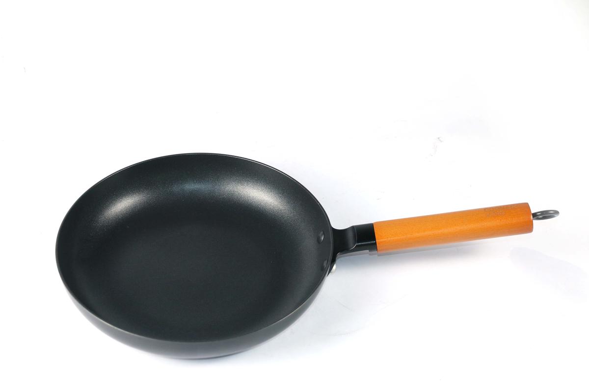 Illustration of someone seasoning a carbon steel frying pan